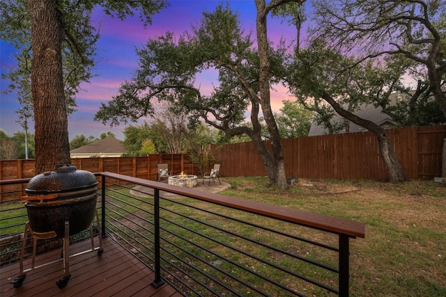 deck at dusk featuring a fire pit