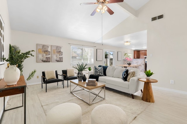 living room with ceiling fan, beamed ceiling, high vaulted ceiling, and light hardwood / wood-style floors