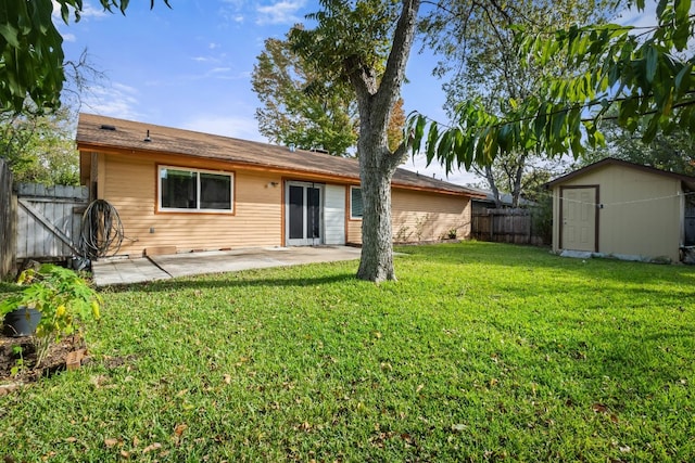 rear view of house with a yard, a shed, and a patio area