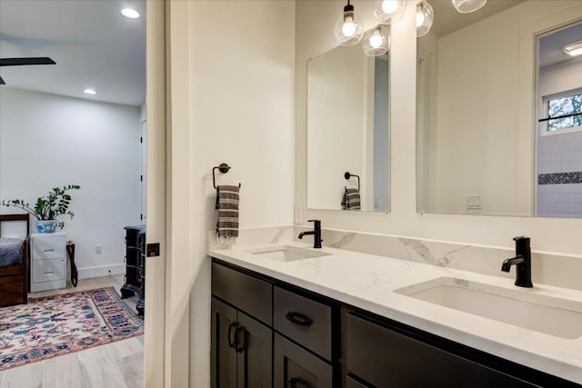 bathroom with hardwood / wood-style flooring, ceiling fan, and vanity