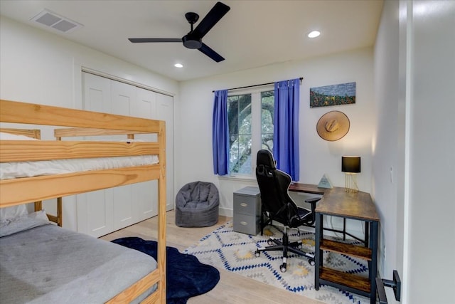 bedroom featuring ceiling fan, light hardwood / wood-style floors, and a closet