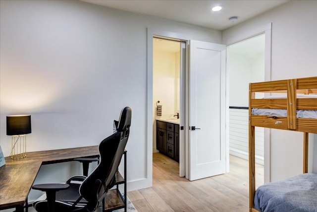 bedroom with connected bathroom and light wood-type flooring