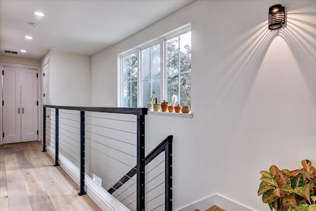 corridor with light hardwood / wood-style floors