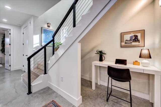 interior space with concrete flooring and built in desk