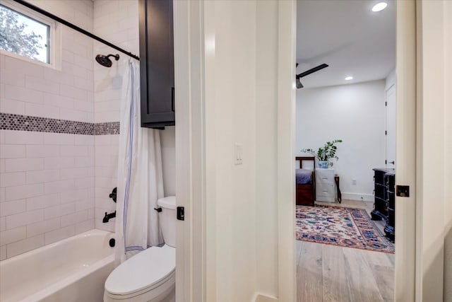 bathroom with wood-type flooring, shower / bath combo, ceiling fan, and toilet