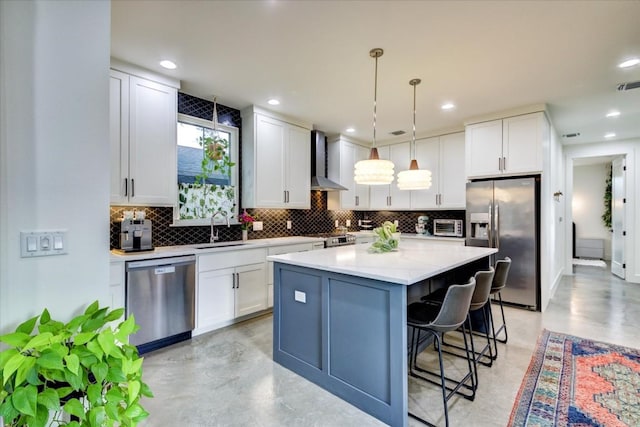 kitchen featuring stainless steel appliances, a center island, white cabinets, and wall chimney exhaust hood