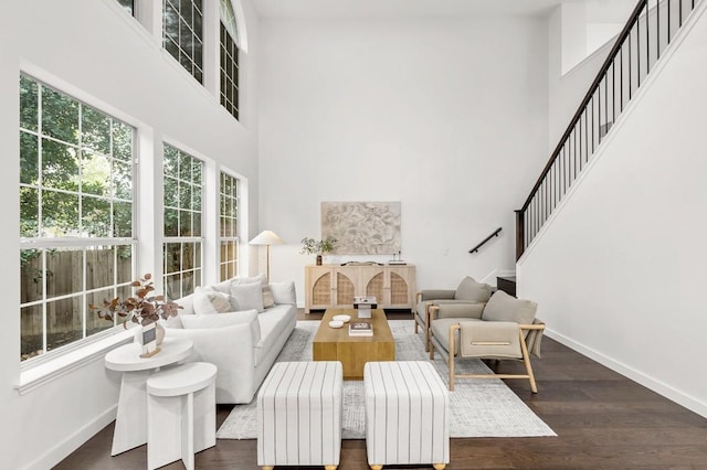 living room with dark hardwood / wood-style floors and a towering ceiling