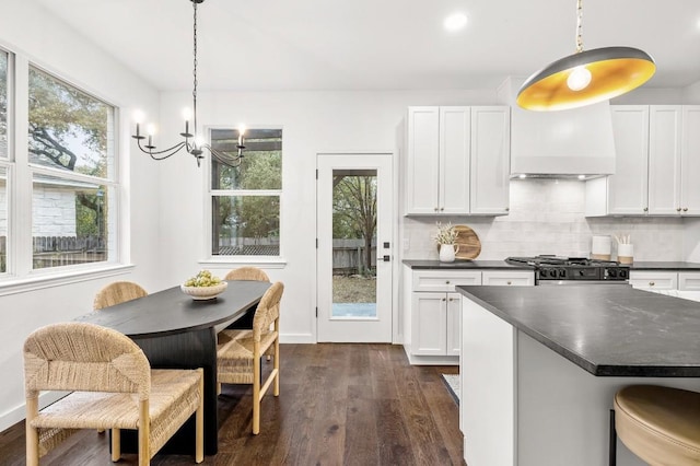 kitchen with white cabinets, hanging light fixtures, and dark wood-type flooring