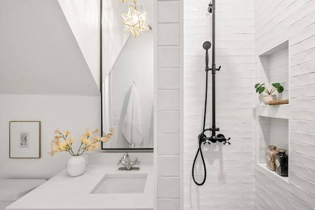 bathroom with tiled shower and sink