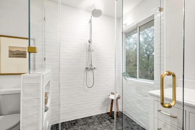 bathroom featuring a wealth of natural light, a shower with door, and toilet