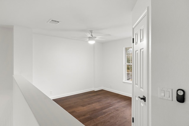 empty room with ceiling fan and dark hardwood / wood-style flooring