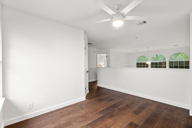 empty room with ceiling fan and dark wood-type flooring