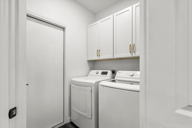 clothes washing area with cabinets and independent washer and dryer