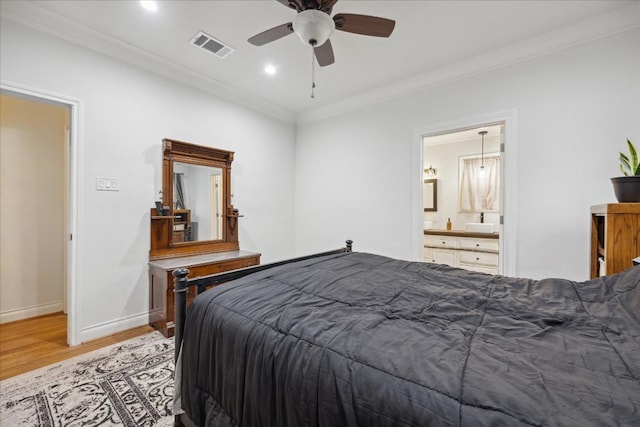 bedroom with crown molding, visible vents, light wood-style flooring, ensuite bathroom, and baseboards