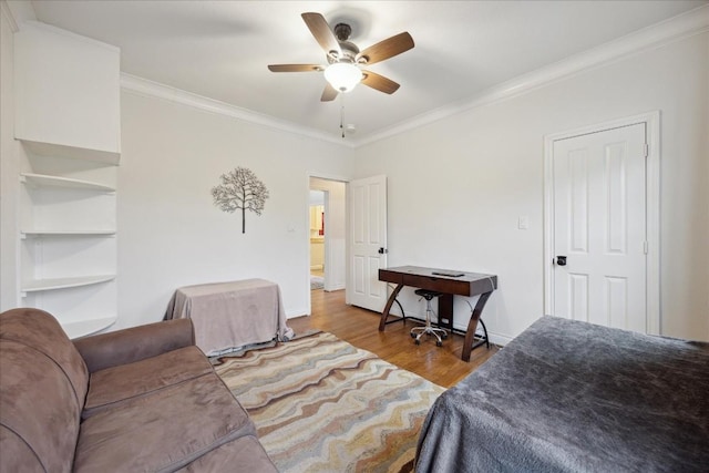 bedroom featuring a ceiling fan, crown molding, baseboards, and wood finished floors