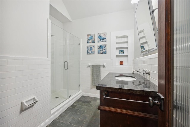 full bathroom with wainscoting, tile walls, a shower stall, and vanity