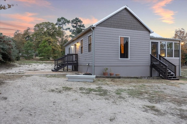 view of side of property featuring stairway and a sunroom