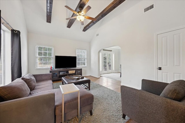 living room with arched walkways, high vaulted ceiling, visible vents, a ceiling fan, and beam ceiling