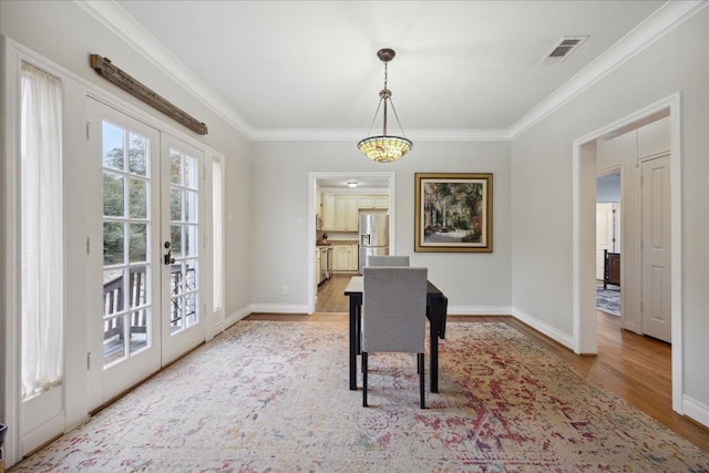 office area featuring light wood finished floors, baseboards, visible vents, crown molding, and french doors