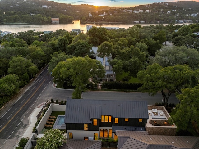 aerial view at dusk featuring a water view