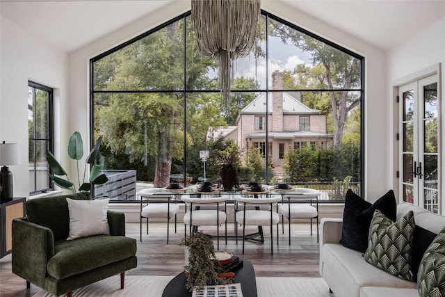 sunroom / solarium featuring french doors, lofted ceiling, and a notable chandelier