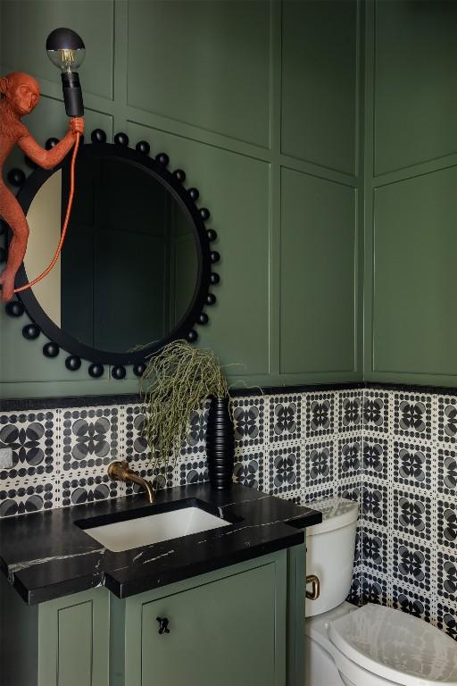 bathroom with vanity, toilet, and backsplash