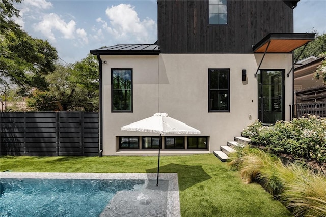 rear view of house featuring a fenced in pool, a yard, and a patio