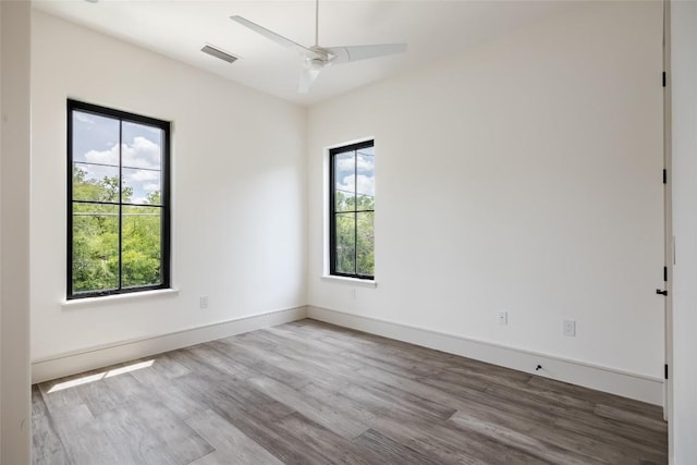 empty room with ceiling fan and light hardwood / wood-style floors