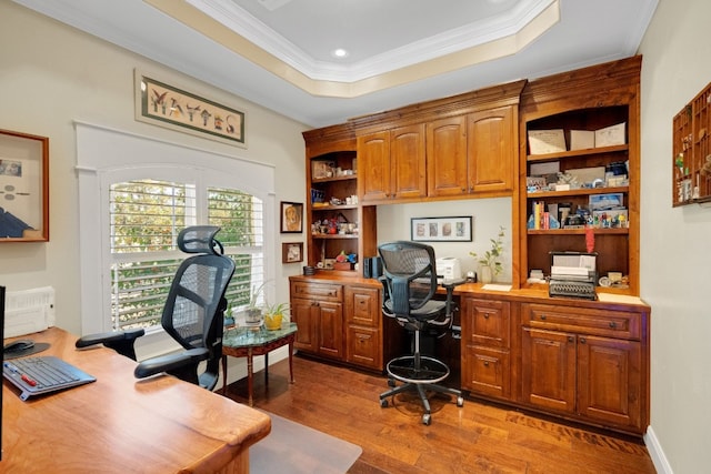 home office featuring hardwood / wood-style floors, a tray ceiling, and crown molding