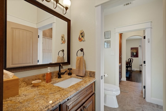 bathroom with wood-type flooring, vanity, and toilet