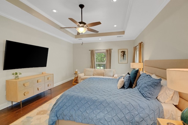 bedroom with ornamental molding, a raised ceiling, ceiling fan, and dark wood-type flooring