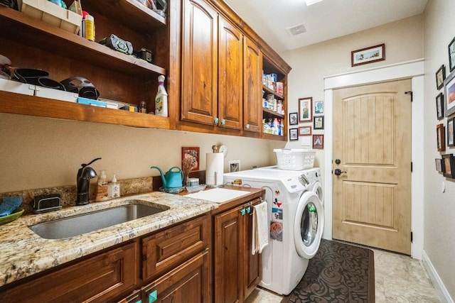 washroom with washer and dryer, light tile patterned flooring, cabinets, and sink