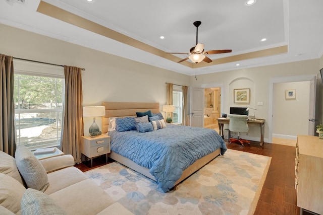 bedroom featuring a raised ceiling, ceiling fan, dark hardwood / wood-style floors, and ornamental molding