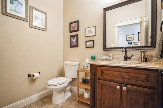 bathroom with tile patterned flooring, vanity, and toilet