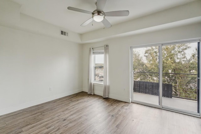 empty room with light hardwood / wood-style floors, plenty of natural light, and ceiling fan