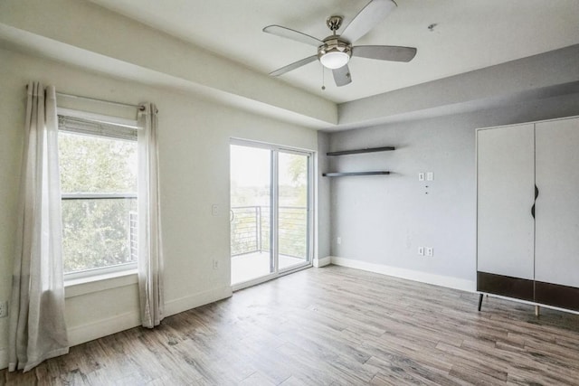 6444 Burnet Rd Unit 305, Austin, TX 78757 - unfurnished bedroom featuring access to exterior, wood finished floors, and baseboards