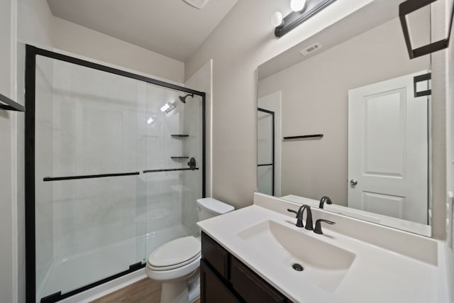 bathroom featuring hardwood / wood-style flooring, vanity, toilet, and an enclosed shower