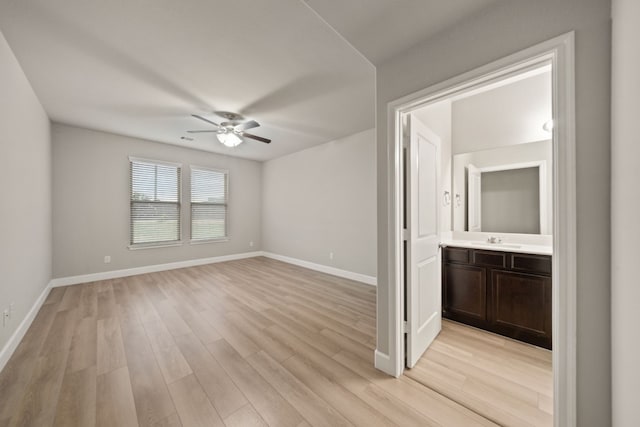 unfurnished room with light hardwood / wood-style floors, ceiling fan, and sink