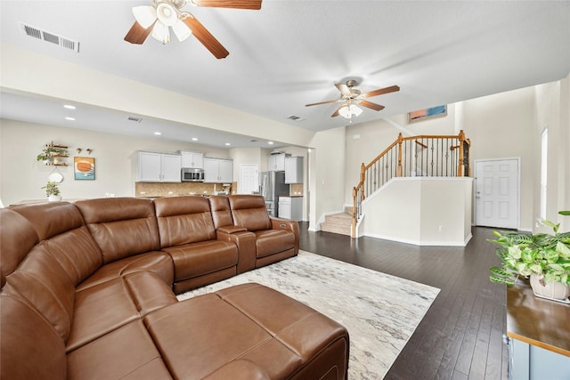 living room featuring ceiling fan and dark wood-type flooring