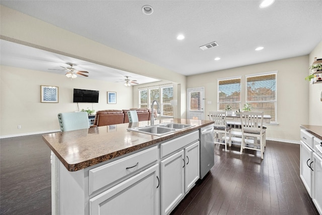 kitchen with a kitchen island with sink, white cabinets, sink, stainless steel dishwasher, and dark hardwood / wood-style flooring