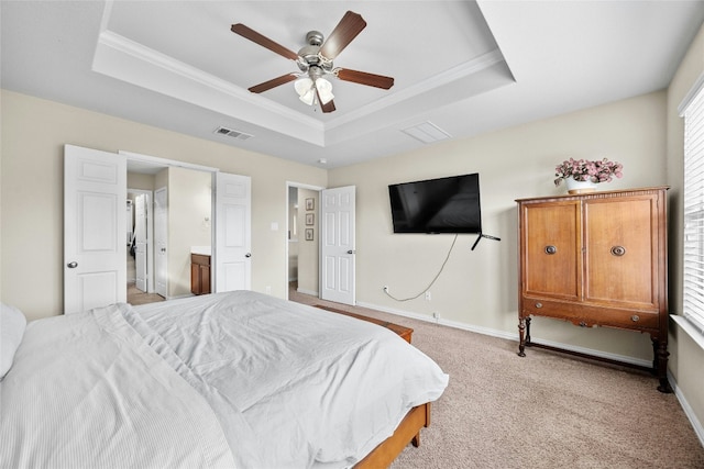 carpeted bedroom with ensuite bath, a raised ceiling, ceiling fan, and ornamental molding