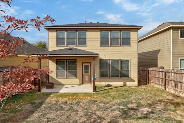 back of property with a yard and a patio