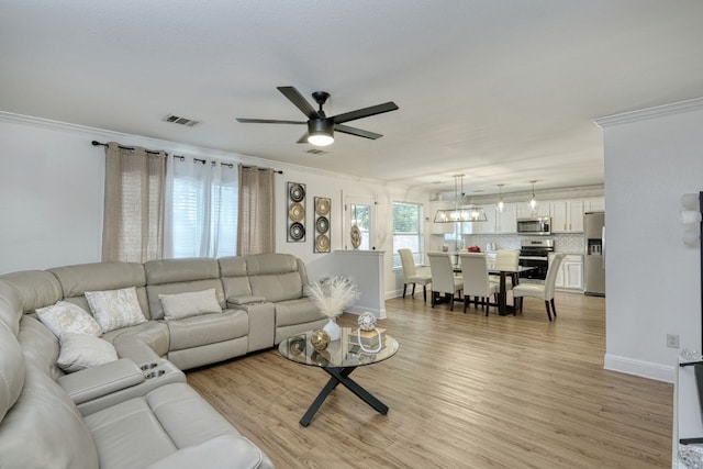 living room featuring ceiling fan, light hardwood / wood-style flooring, and ornamental molding