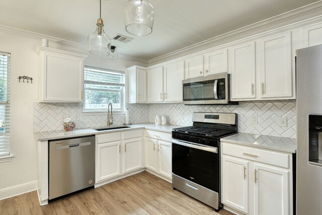 kitchen featuring white cabinetry, sink, stainless steel appliances, and light wood-type flooring