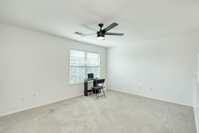 unfurnished office with ceiling fan and light colored carpet