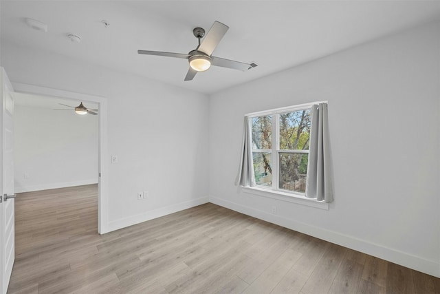 empty room with ceiling fan and light wood-type flooring