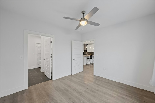 unfurnished bedroom featuring ceiling fan and dark hardwood / wood-style floors