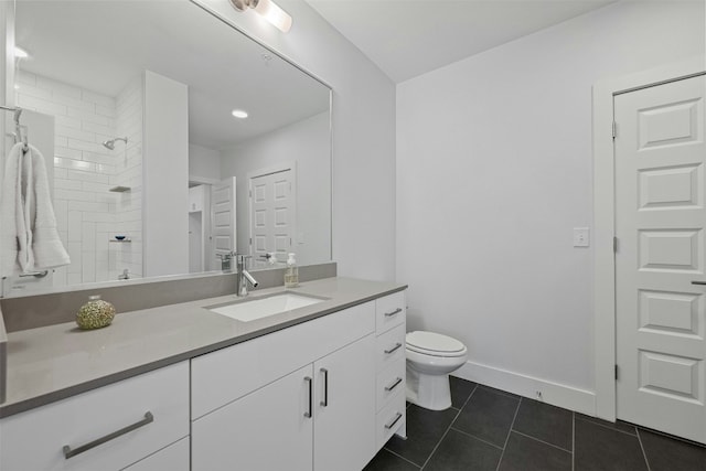 bathroom with tiled shower, tile patterned flooring, vanity, and toilet