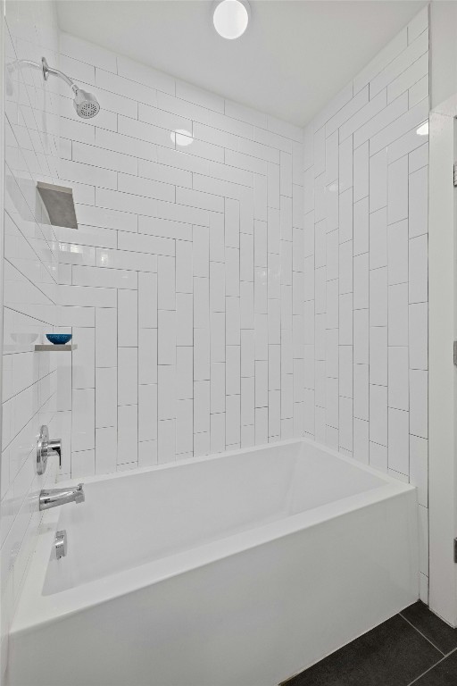 bathroom featuring tile patterned flooring and tiled shower / bath