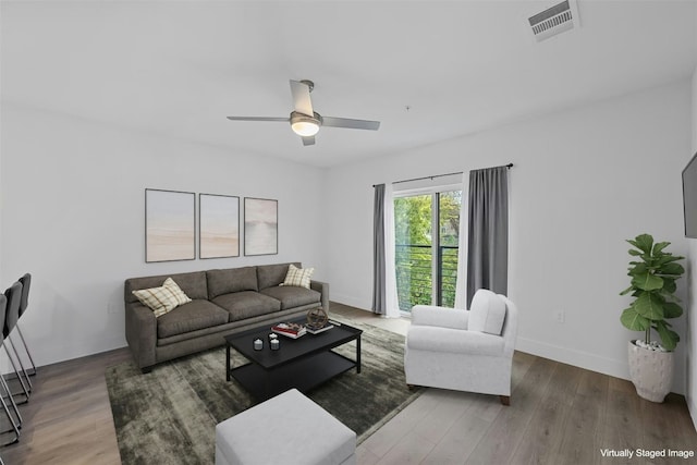 living room featuring ceiling fan and dark hardwood / wood-style floors